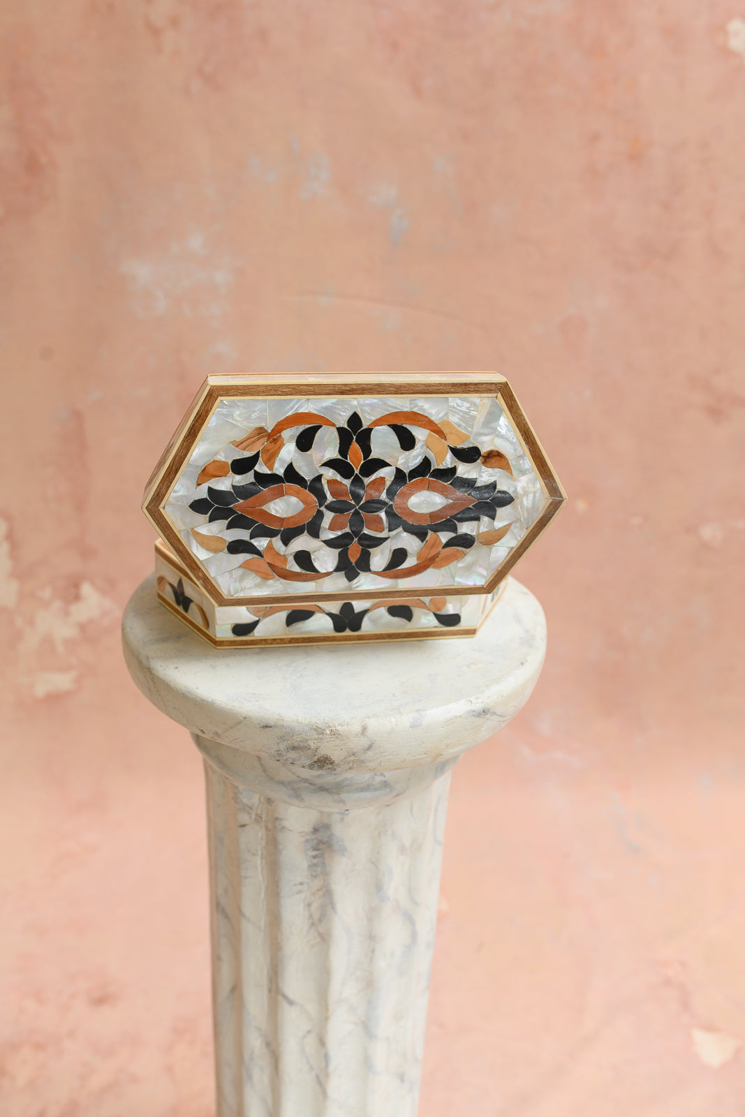 Top view of elongated white mother-of-pearl keepsake box with vine and petal inlay