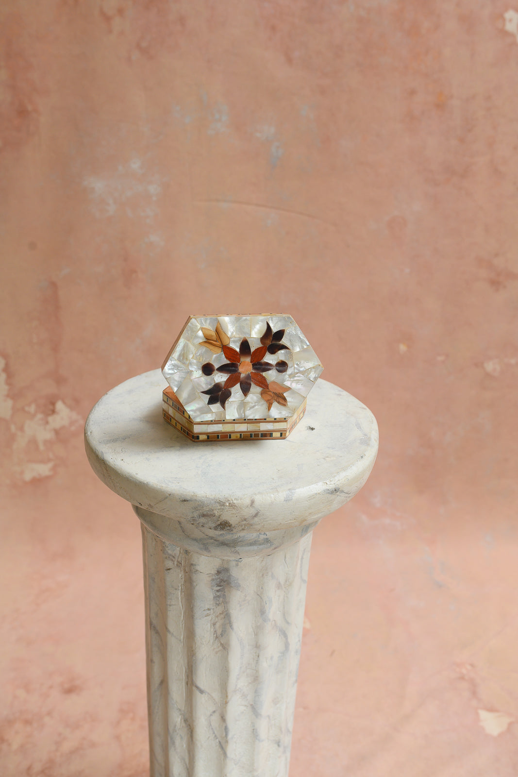 Top view of hexagon mother-of-pearl keepsake box with wood flower medallion