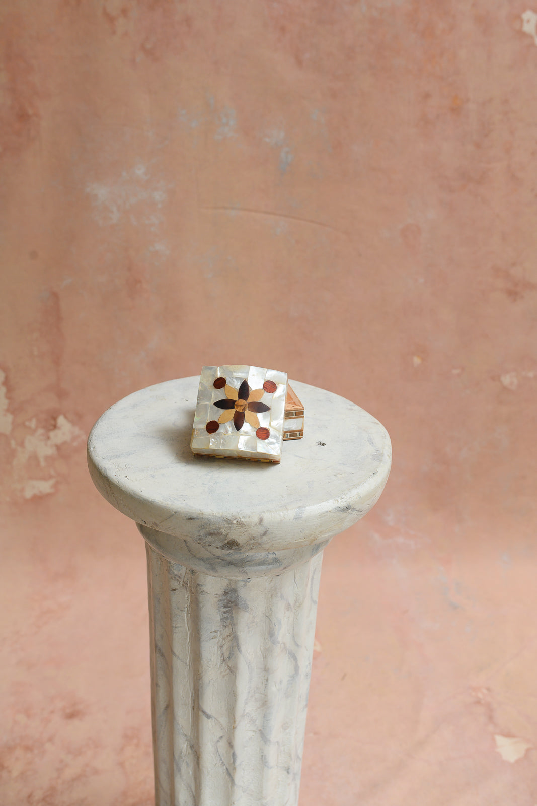 Top view of small mother-of-pearl ring box with flower medallion