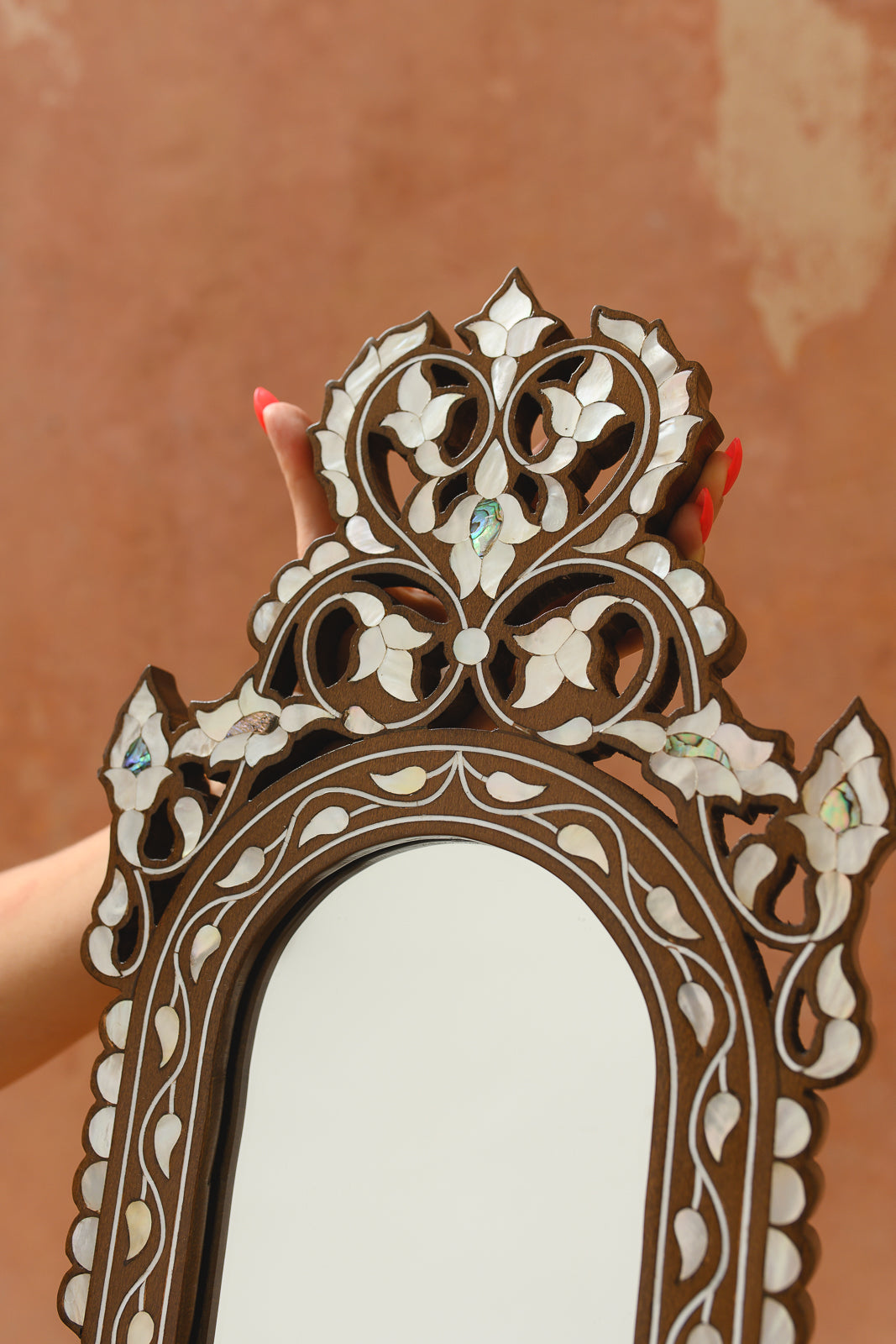 Detail of mother-of-pearl vine inlay along arched mirror frame