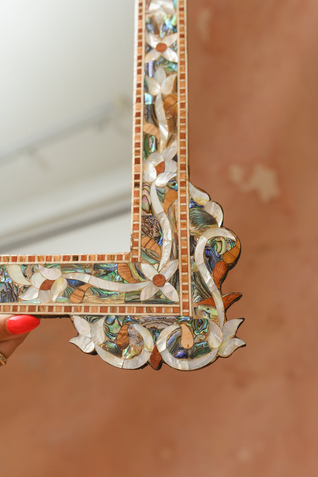 Close-up of hand-cut shell and wood inlay on Damascus mirror corner