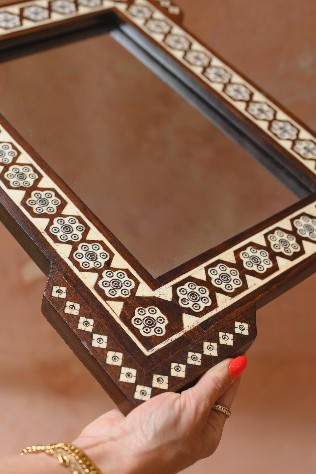 Close-up of hand-cut bone inlay diamonds on Damascus mirror corner